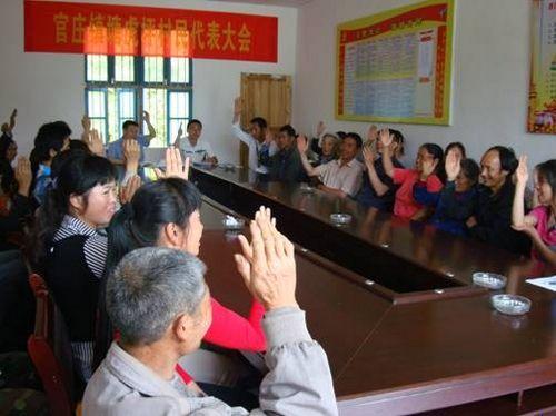 村民代表举手表决《计划生育村民自治章程》.