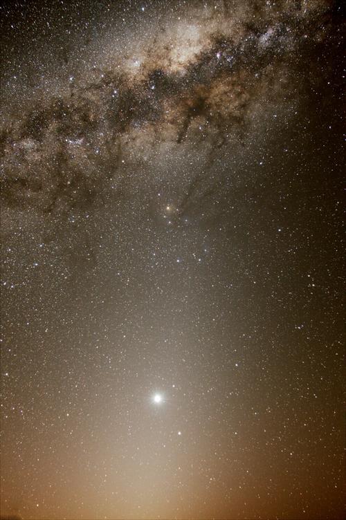 在影像顶端,长河状的尘埃,看似从银河中心往天蝎座