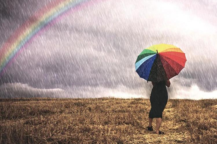 世界气象组织   一名女性打着伞走在雨中
