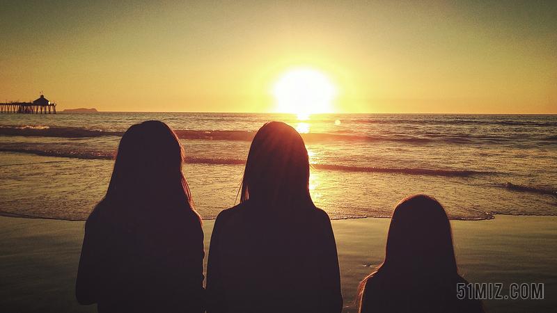 黄黑人物安静看着海面落日的三个女孩背影旅游黄昏大海背景图片