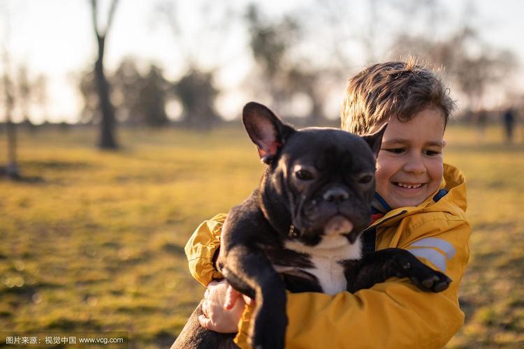 一个快乐的男孩抱着一只小狗