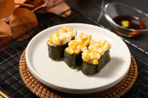 桌面上的盘子里的美味可口的玉米军舰寿司
