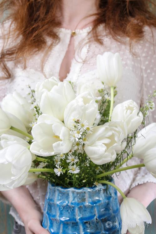 女人抱着白色郁金香花束