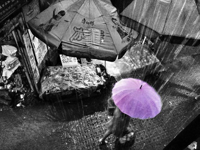 暴雨的夜晚,一个女孩打着伞走在雨中