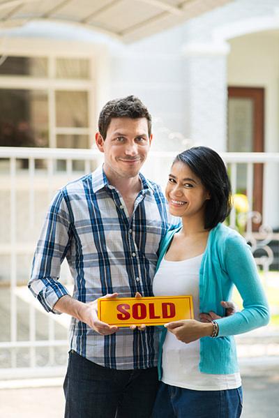 picture of a heterosexual couple standing in front of a house