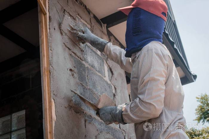 建筑工人用水泥浆粉刷建筑墙面