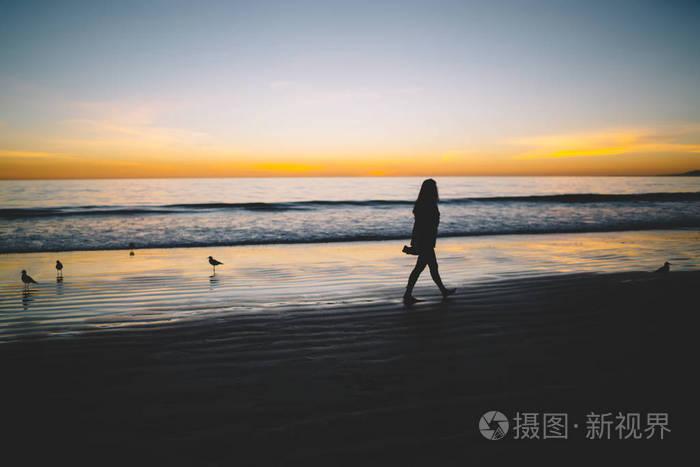 孤独的女人剪影在宁静的海洋的沙滩上 sceni 日落时, 不安的女孩走近